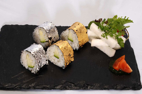 Sushi rolls decorated with silver & gold warq Sushi rolls decorated with silver & gold warq